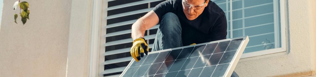 pexels-photo-9875408-9875408 Solar technician installing a photovoltaic panel on a rooftop, promoting renewable energy.